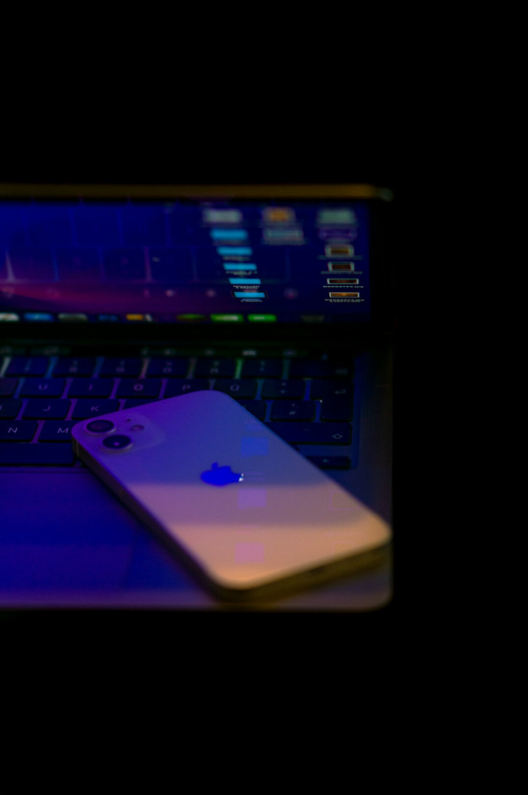 Laptop and phone displaying a code editor with colorful syntax highlighting